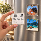 Hand placing a boarding pass magnet on the fridge next to photo magnets